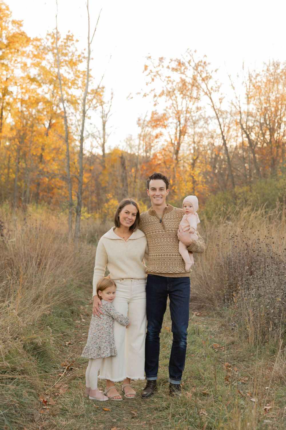 family of four smiling for a fall photo at Douglas evans nature preserve in Beverly Hills michigan