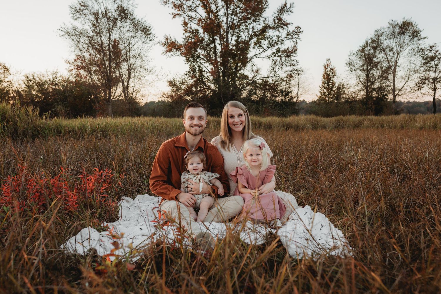 Romantic sunset engagement session in a rustic field with warm autumn colors.