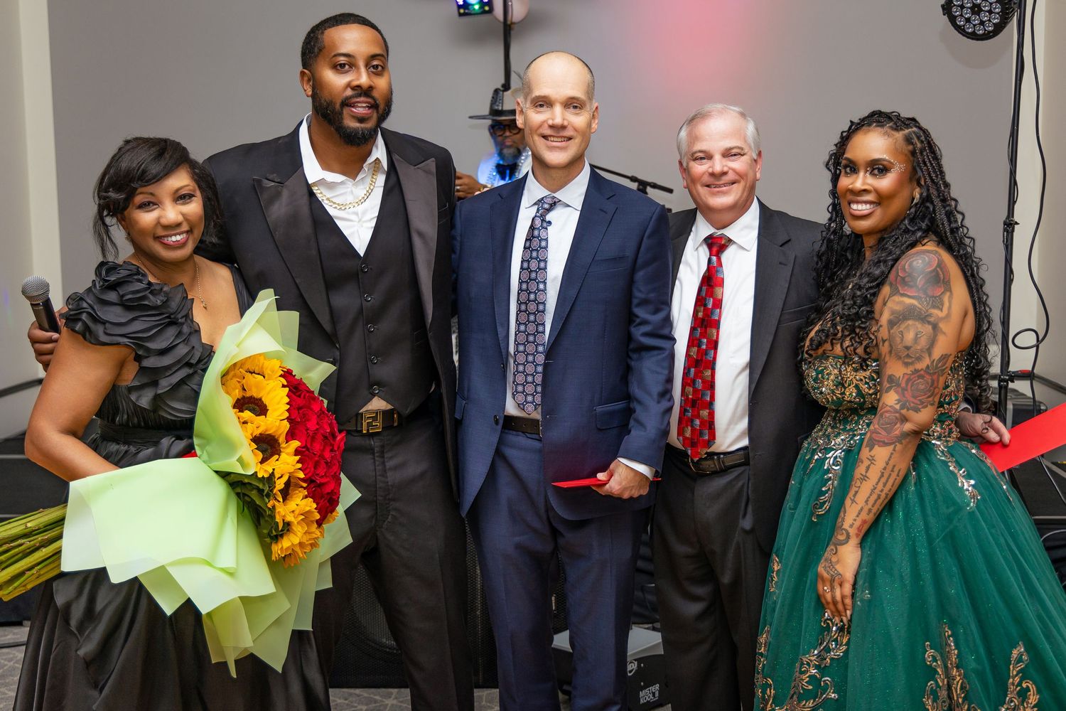 Group of formally dressed people posing together at an event.