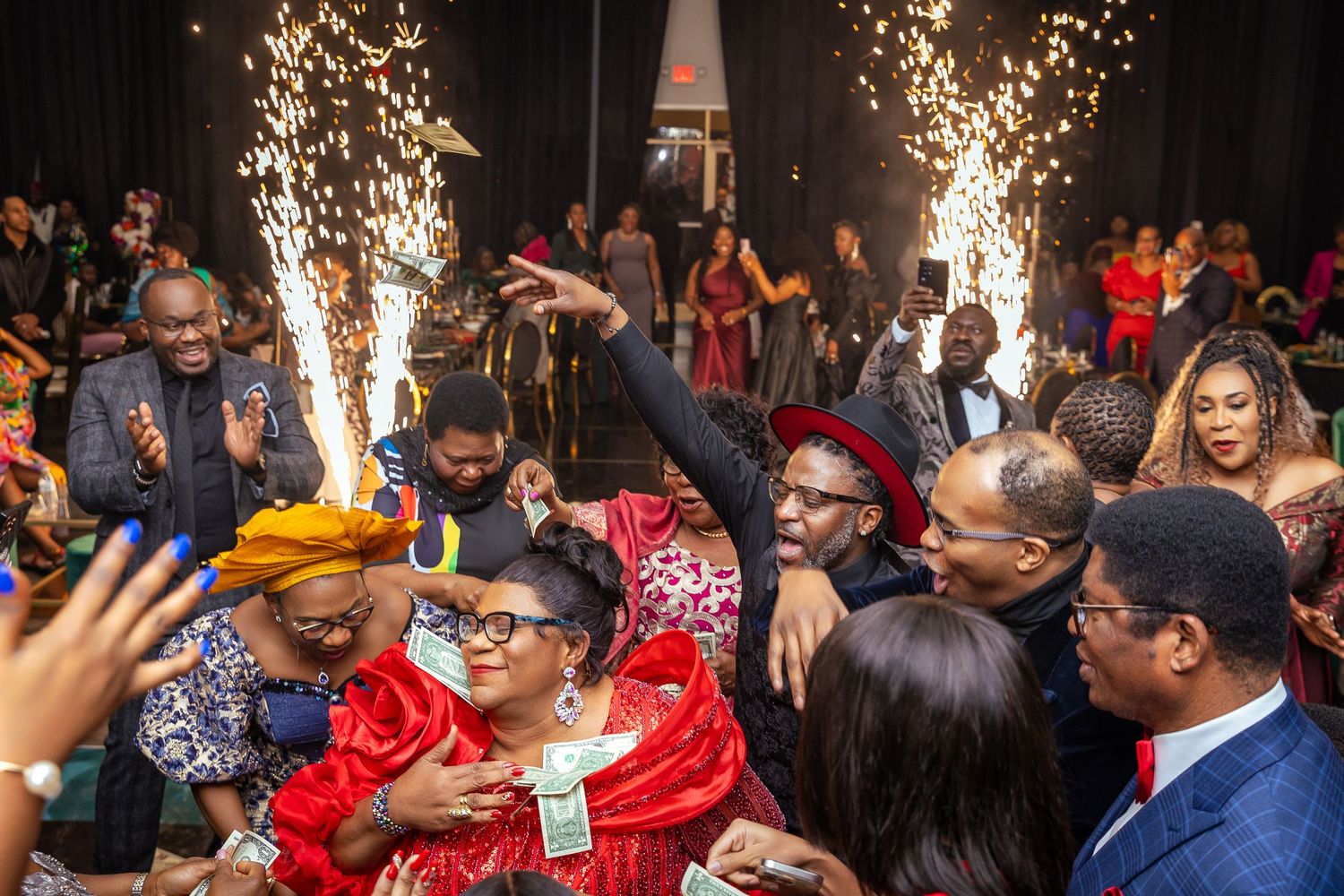 Excited crowd celebrates at nightclub with sparkler pyrotechnics during lively party atmosphere.