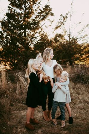 A candid family photoshoot in a rustic outdoor setting with natural lighting.