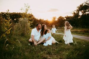 Beautiful family lifestyle session in a golden field at sunset.
