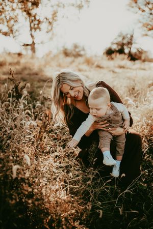 Loving family moment captured in warm autumn light among golden wildflowers and tall grass.