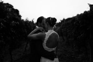 Romantic black and white silhouette of couple embracing in vineyard.