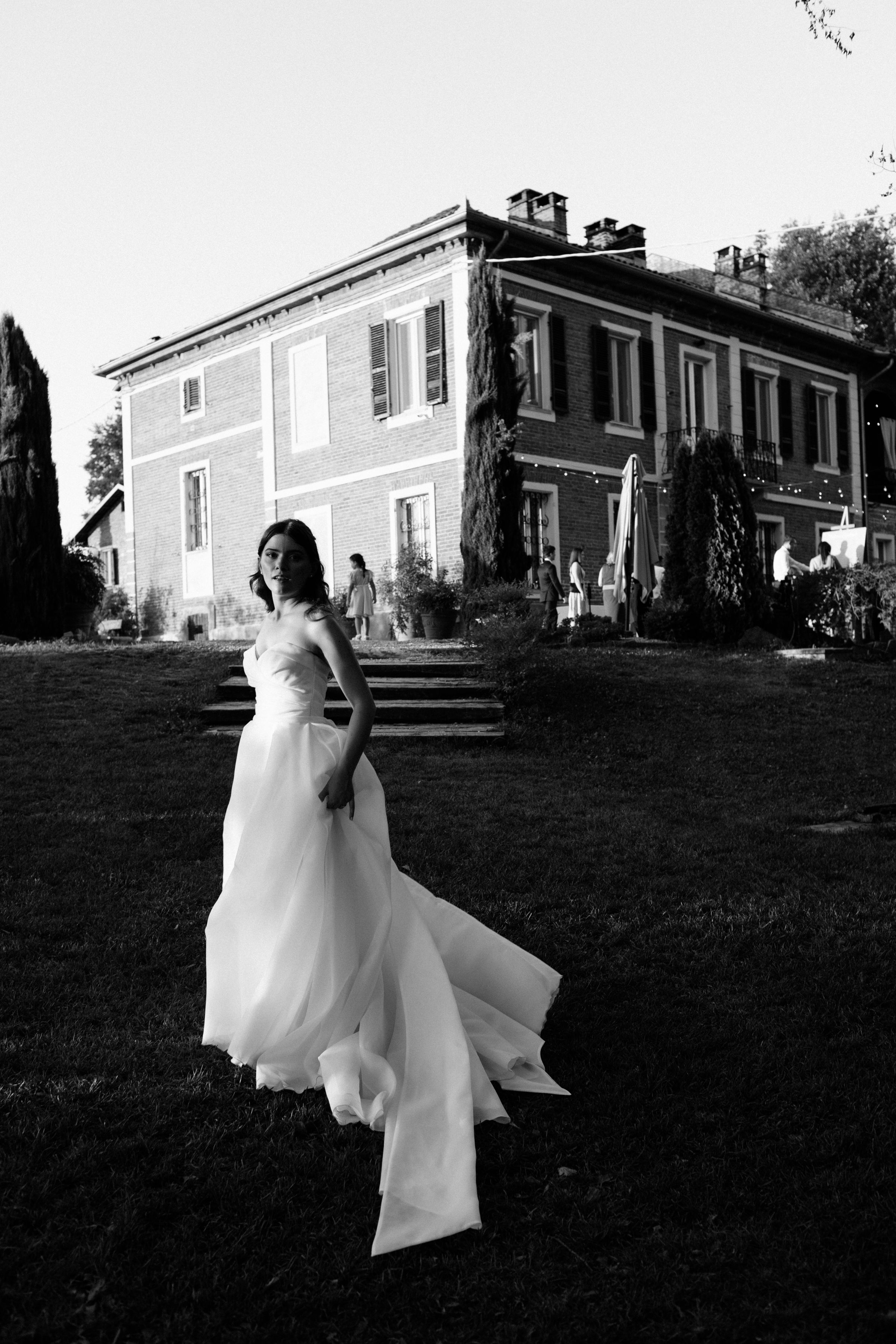 A sequence of black and white photos shows a figure in a flowing white dress walking across a grassy lawn.