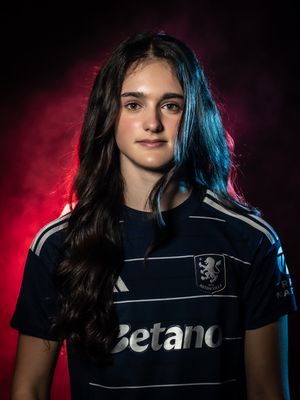 Athletic portrait against red and blue lighting showing player in dark striped jersey with long dark hair and Betano sponsor.