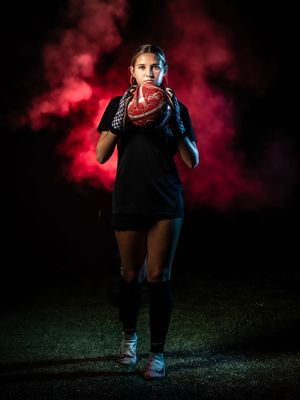A dramatic portrait shoot against red smoke and moody lighting shows a person in casual attire in various athletic poses.
