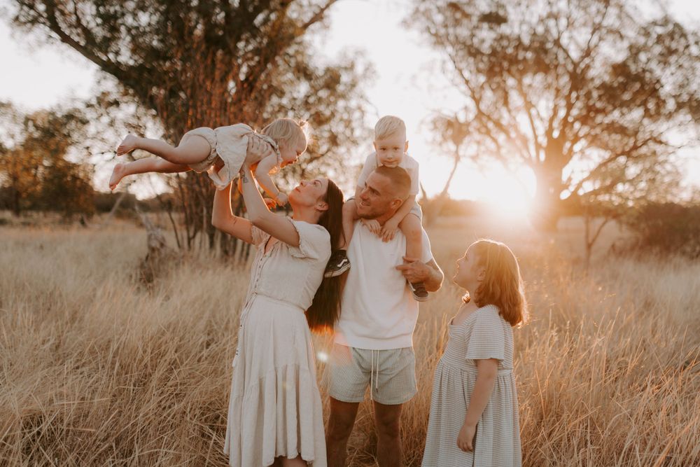 Candid family portrait session in a rustic outdoor setting during golden hour.