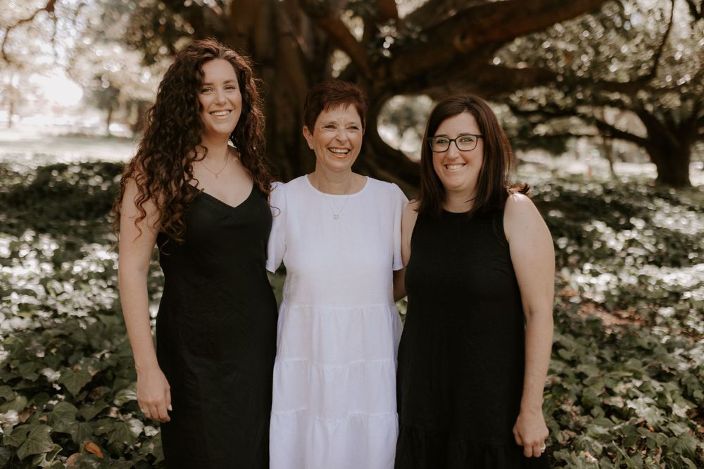 Group portrait under trees with natural lighting.