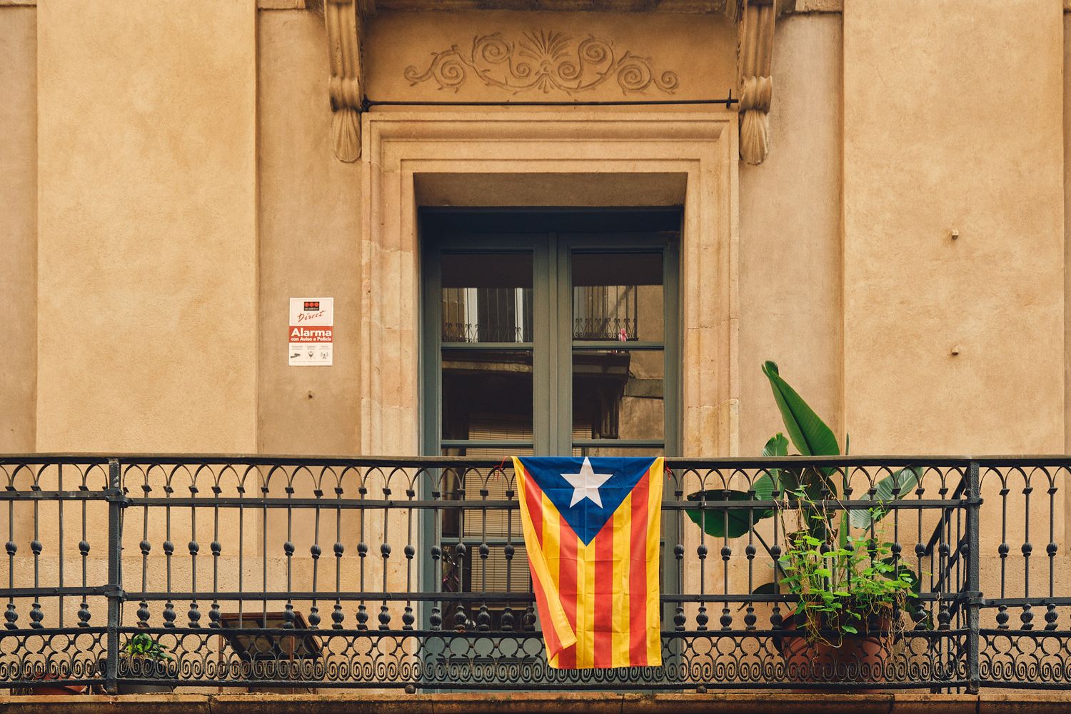Catalan independence flag displayed on a balcony of a historic building in Barcelona, Spain.