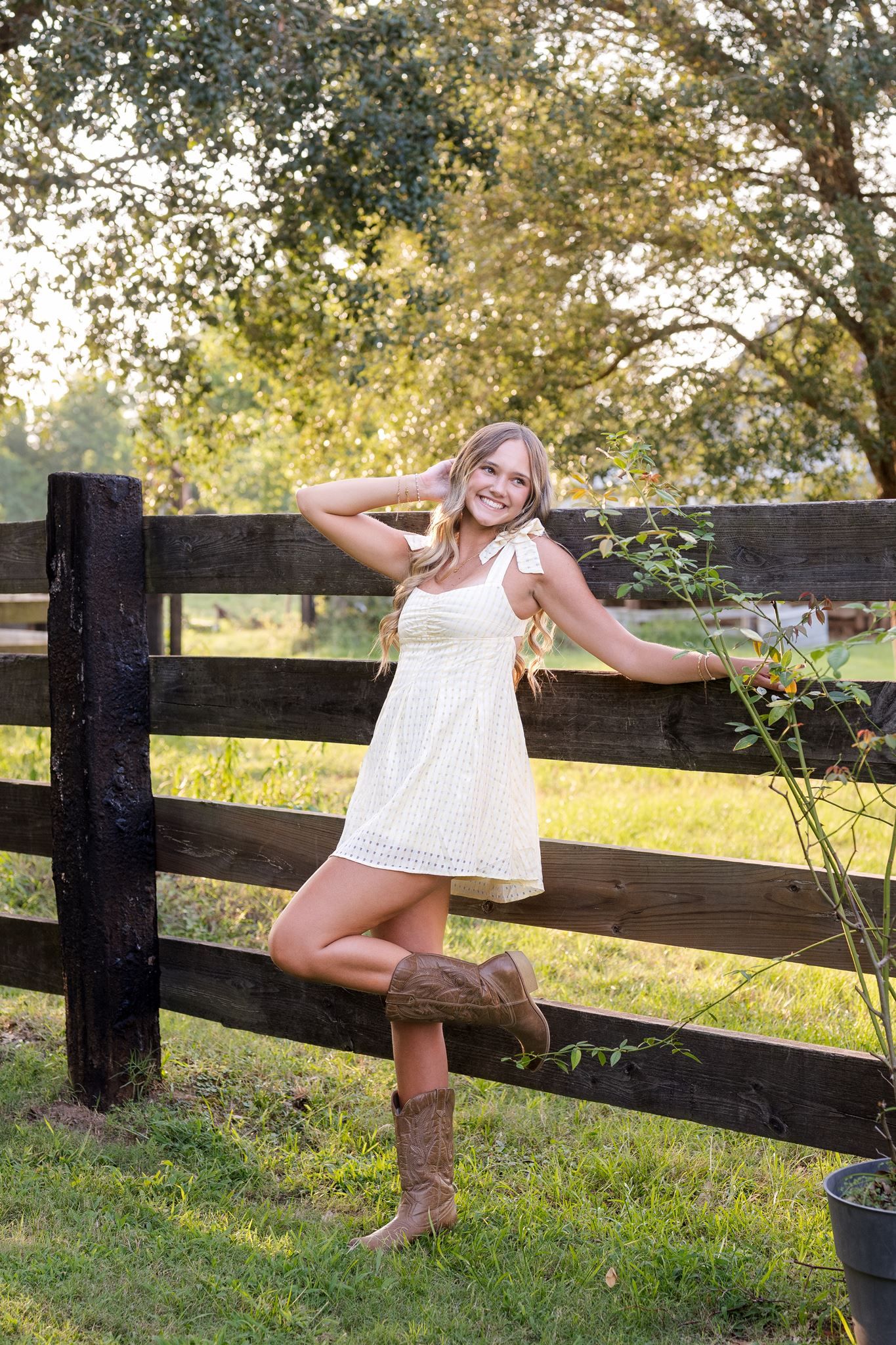 College Park High School senior girl posing on a wooden fence in Tomball Texas