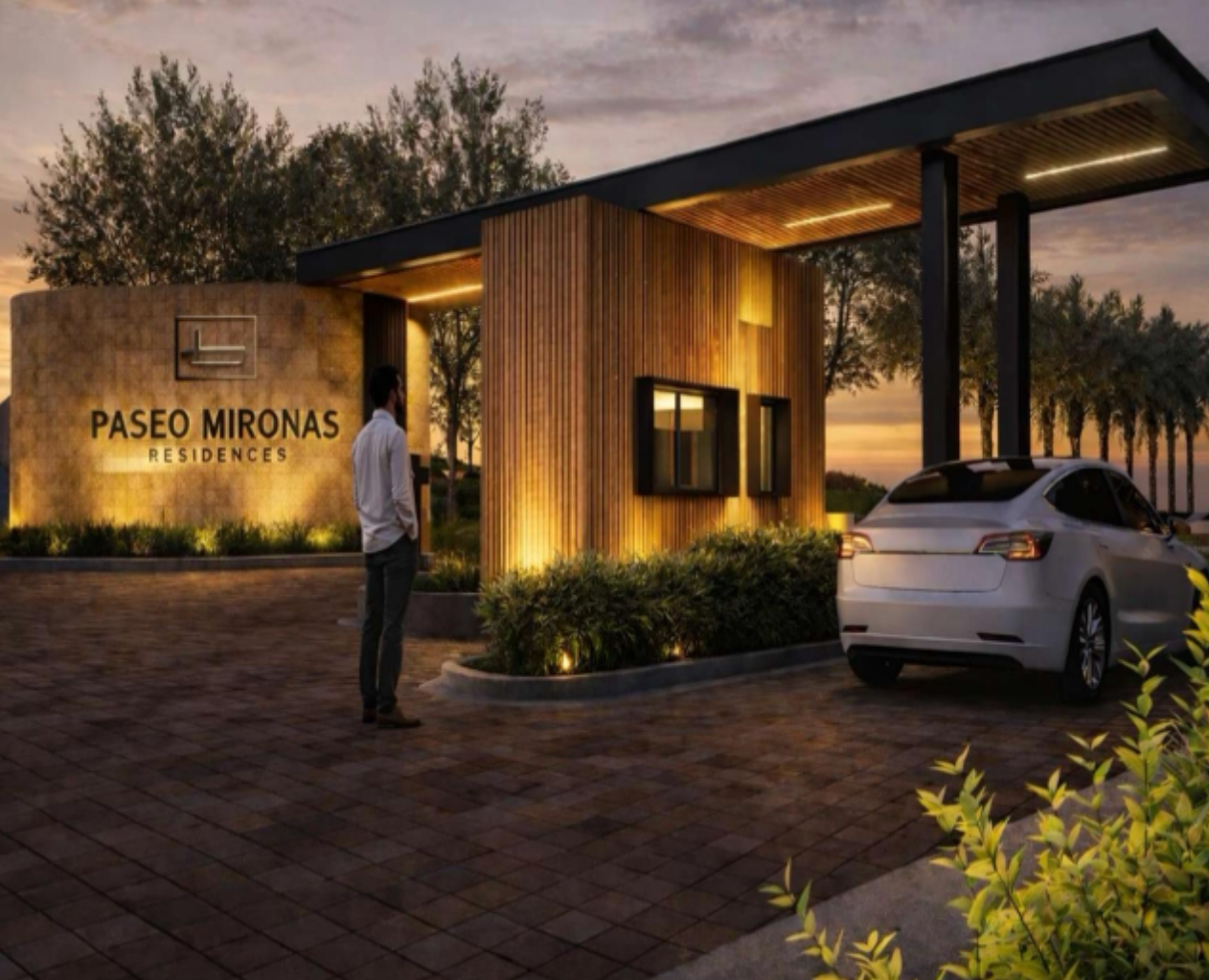 Elegant gated entrance to Paseo Mironas Residences luxury housing development at dusk with Tesla.