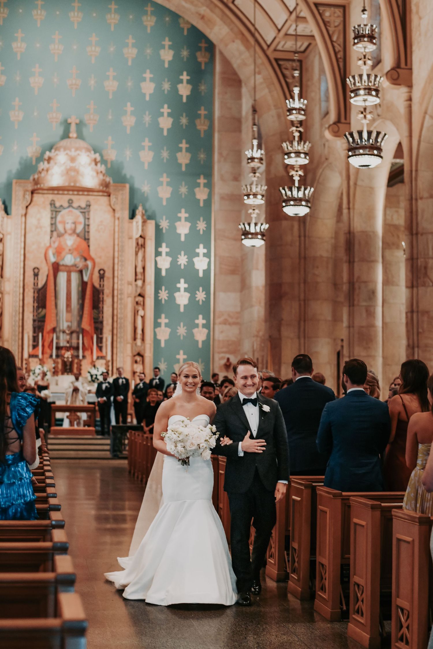 Newlyweds walking down the aisle at Christ the King Catholic Church