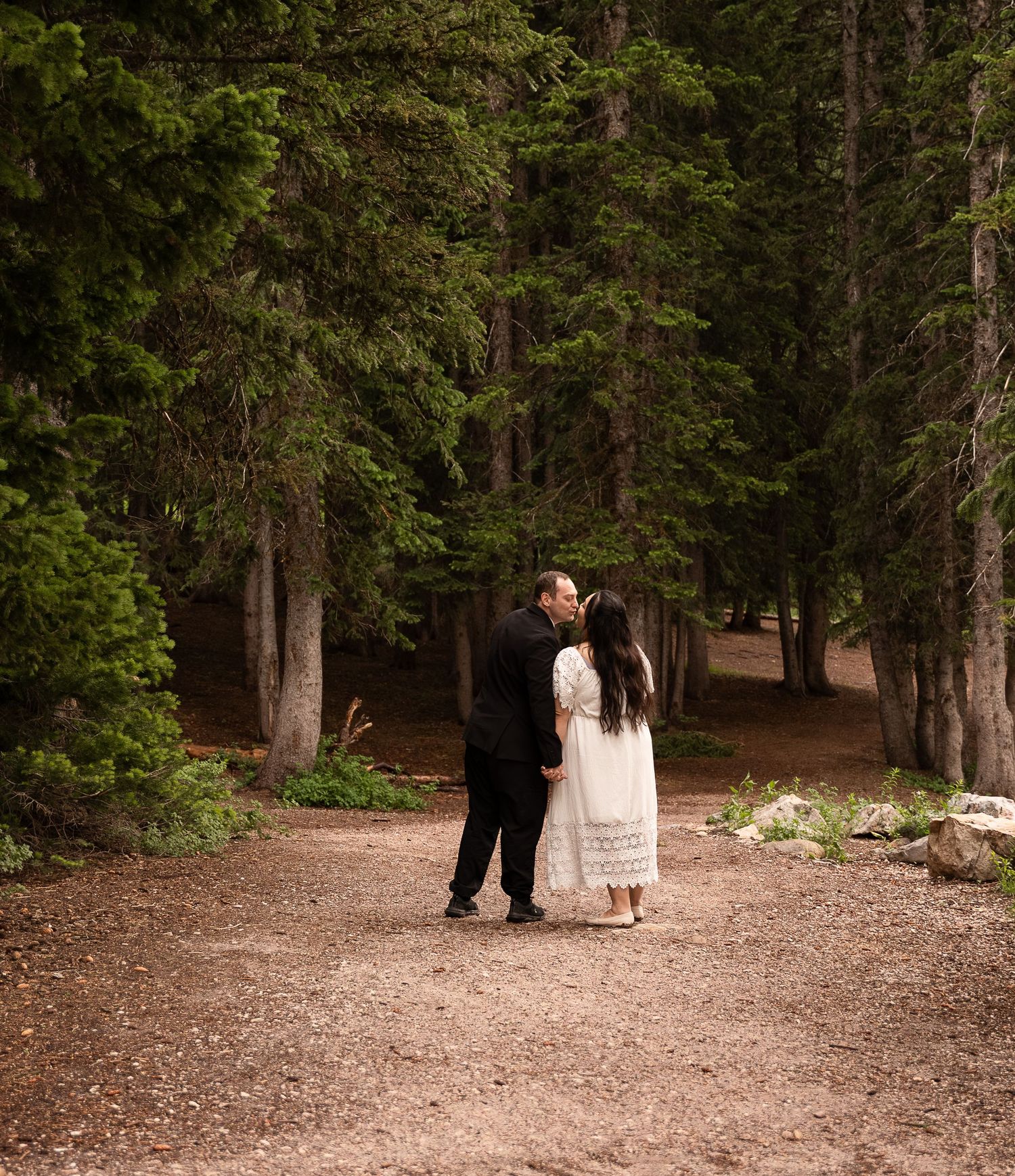 Couple enjoying bridals in tony's grove in logan canyon surrounded by green tall forest trees.