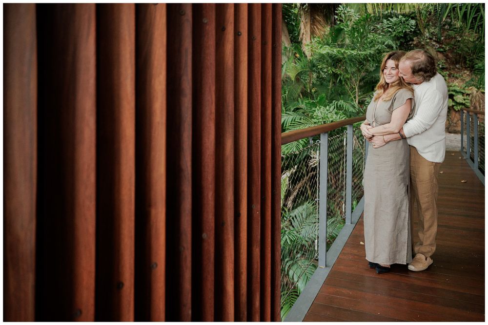 Anniversary Photography at One & Only Mandarina Resort capturing a couple embracing on a private wooden terrace surrounded by tropical.