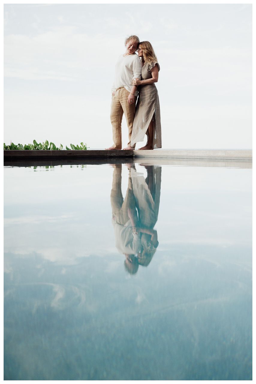 Romantic Vacation Photos at One & Only Mandarina Resort with an engaged couple embracing beside the infinity pool and reflected in the water
