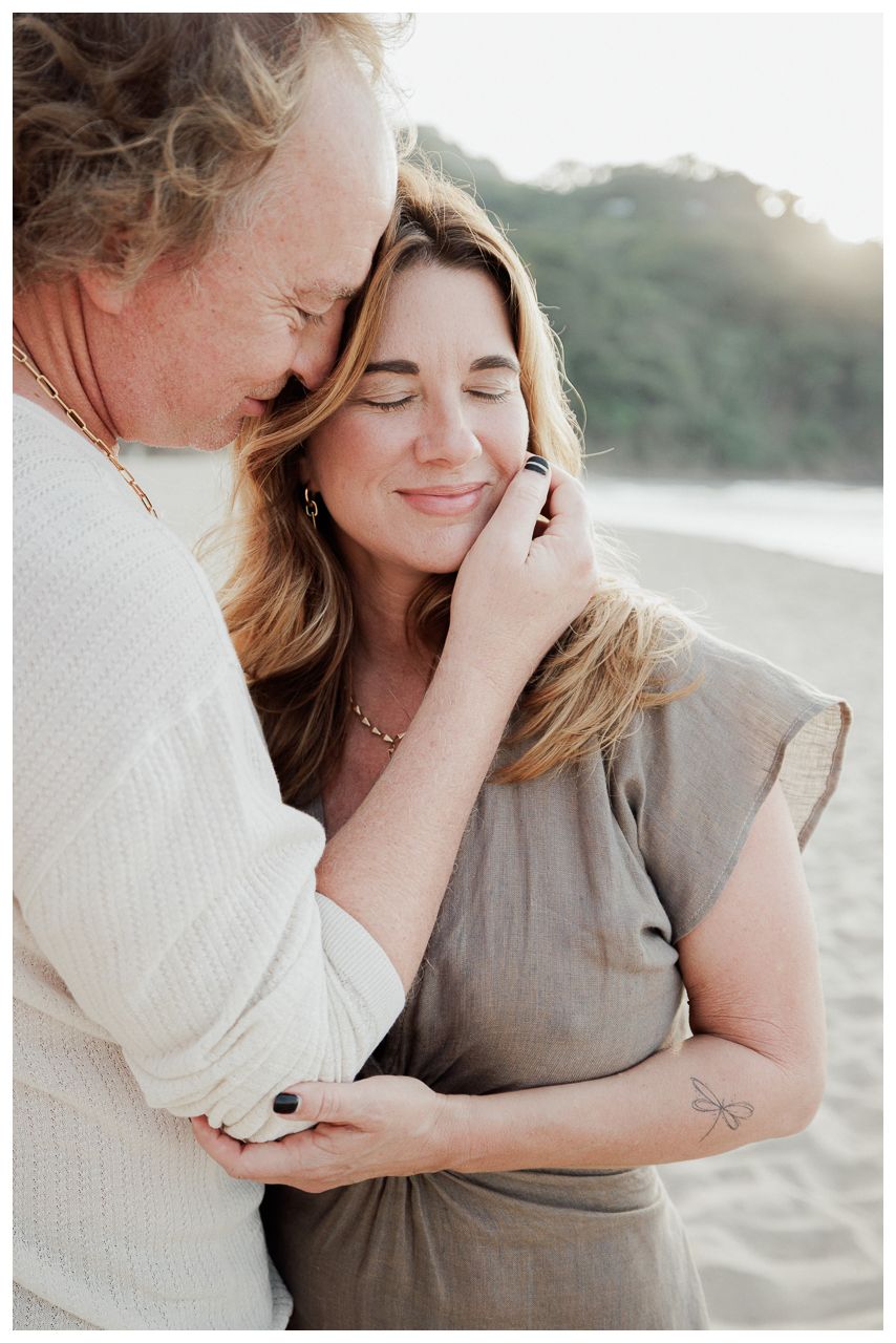 Anniversary Photography at One & Only Mandarina Resort with an engaged couple sharing a tender embrace on the beach at sunset.