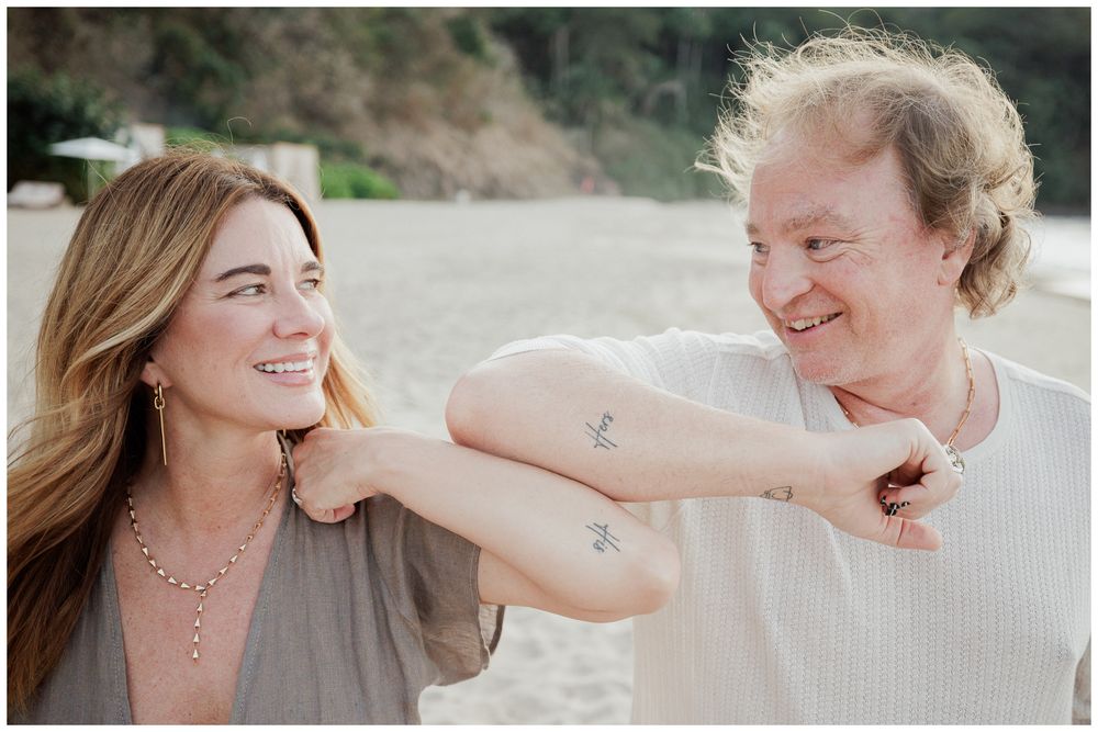 Couples Photo Session at One & Only Mandarina Resort featuring two women sharing a playful moment on the sandy beach.