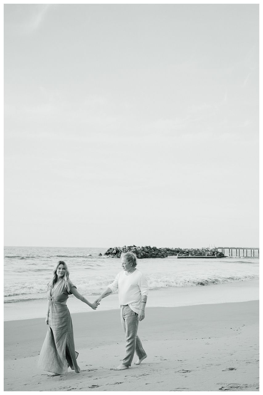 Romantic Vacation Photos at One & Only Mandarina Resort with partners walking hand in hand along the beach beside ocean waves.
