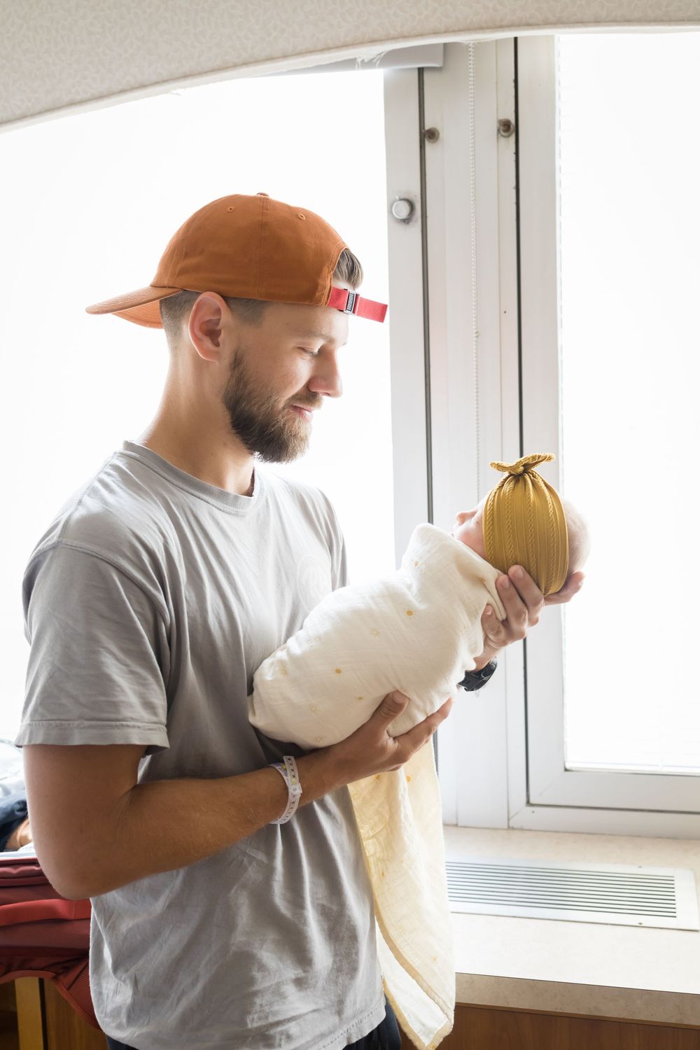 Bearded man in orange cap holding a wrapped melon near a bright window indoors. Images at Fort Sanders Medical Center in Knoxville, TN.