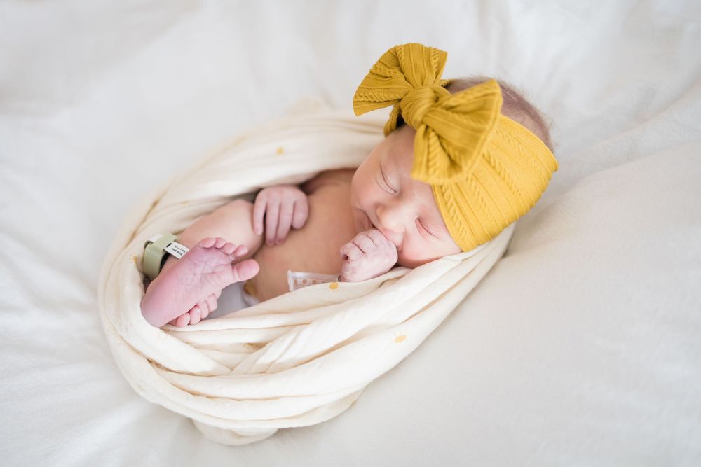 Newborn baby swaddled in cream wrap. Images at Fort Sanders Medical Center in Knoxville, TN by Nina Thomas Photography.