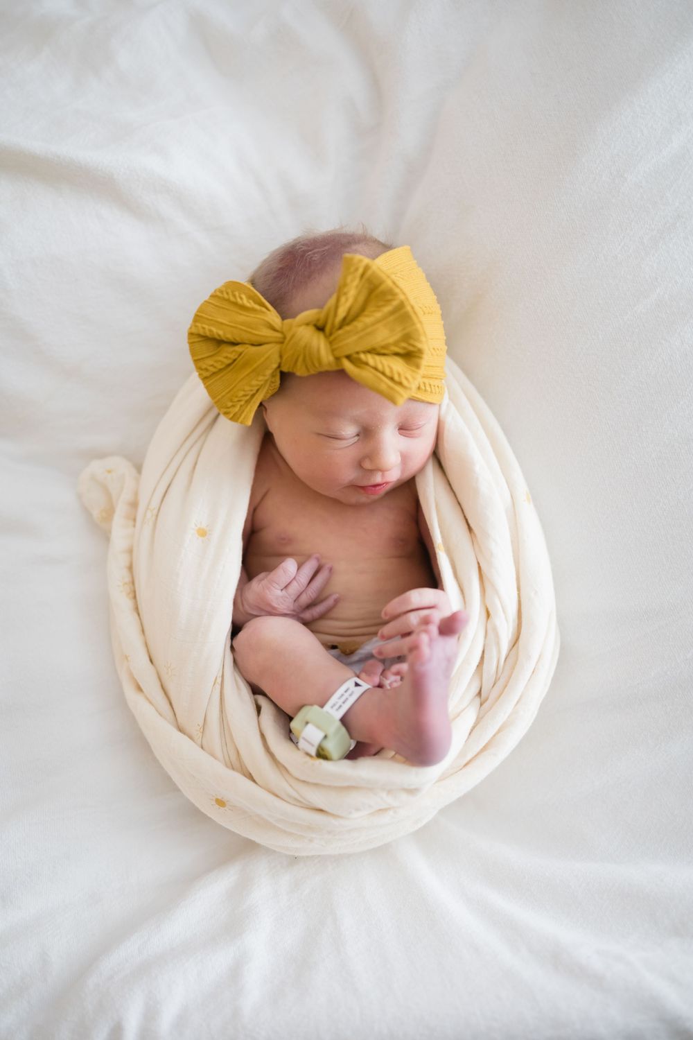 Newborn baby girl swaddled in cream wrap Images at Fort Sanders Medical Center in Knoxville, TN by Nina Thomas Photography.