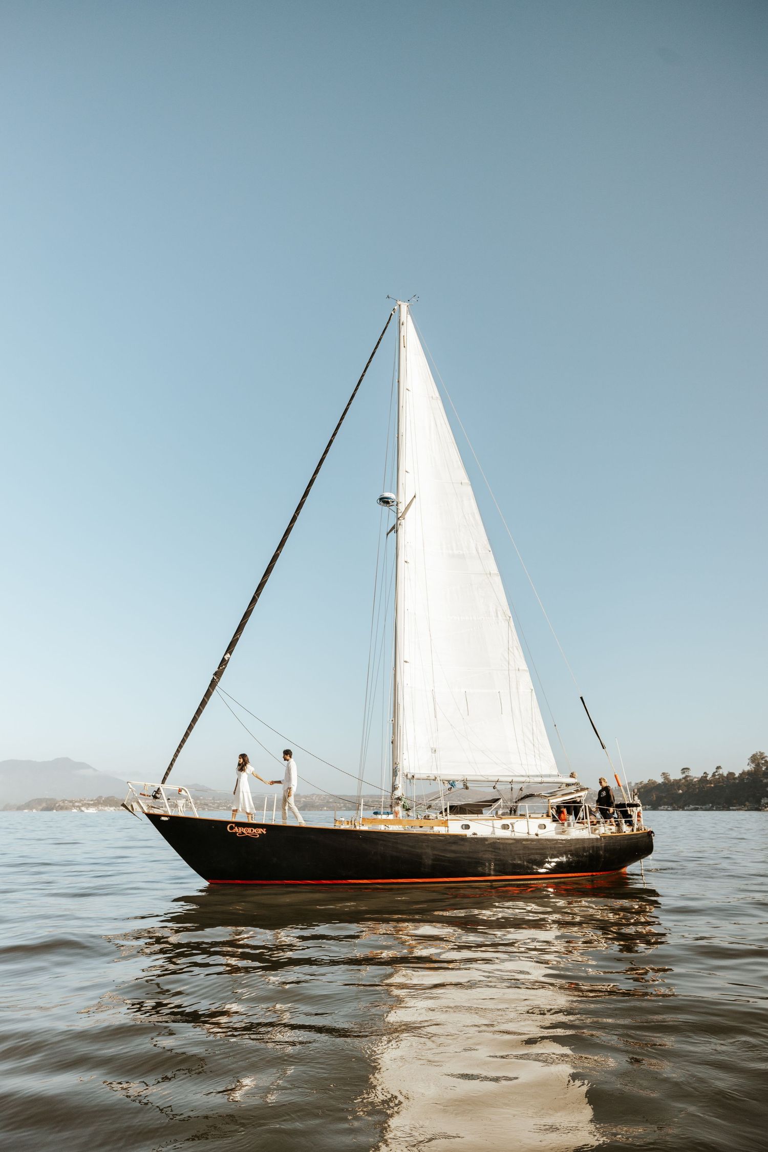 couple walking to bow of sailboat off of Sausalito in the San Francisco bay