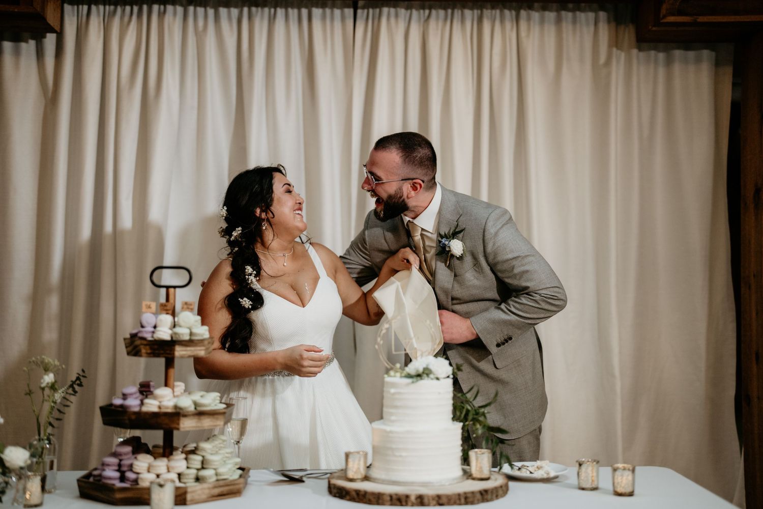 Husband and wife putting cake on eachothers noses during cake cutting in Olympia Wa
