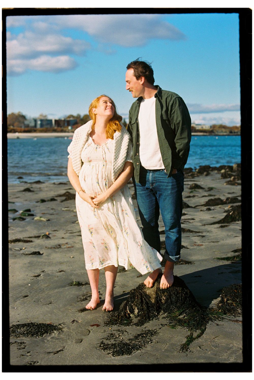 Couple sweetly looking at each other on color 35mm film while standing barefoot on the beach by the ocean at Willard beach in South Portland