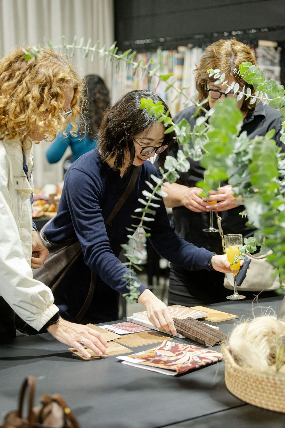 People browsing material swatches and design samples at an interior design showcase event.