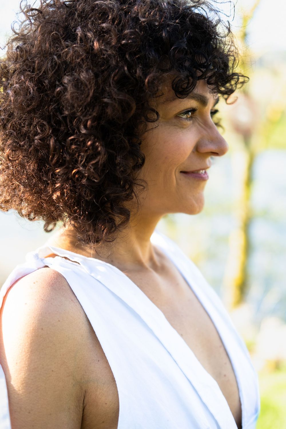 Portrait rapproché d'une femme en lumière naturelle avec arrière-plan doux et lumineux.