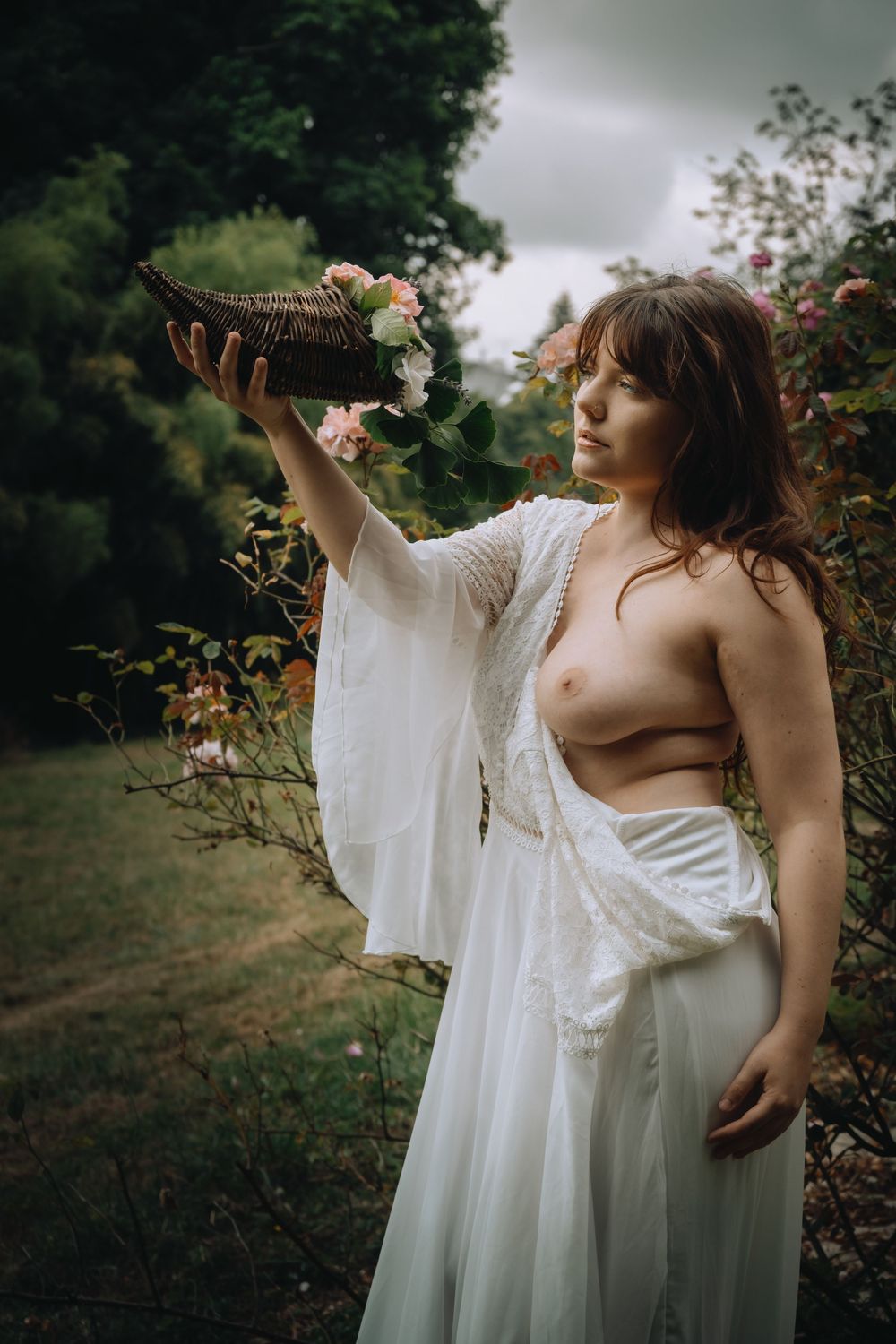 Portrait artistique d'une femme tenant une corne d'abondance fleurie dans un jardin, inspiré de la peinture classique.
