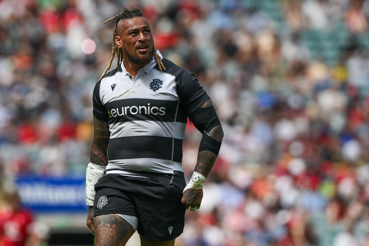 Rugby player in black and white Barbarians jersey with Euronics sponsor on field during match.