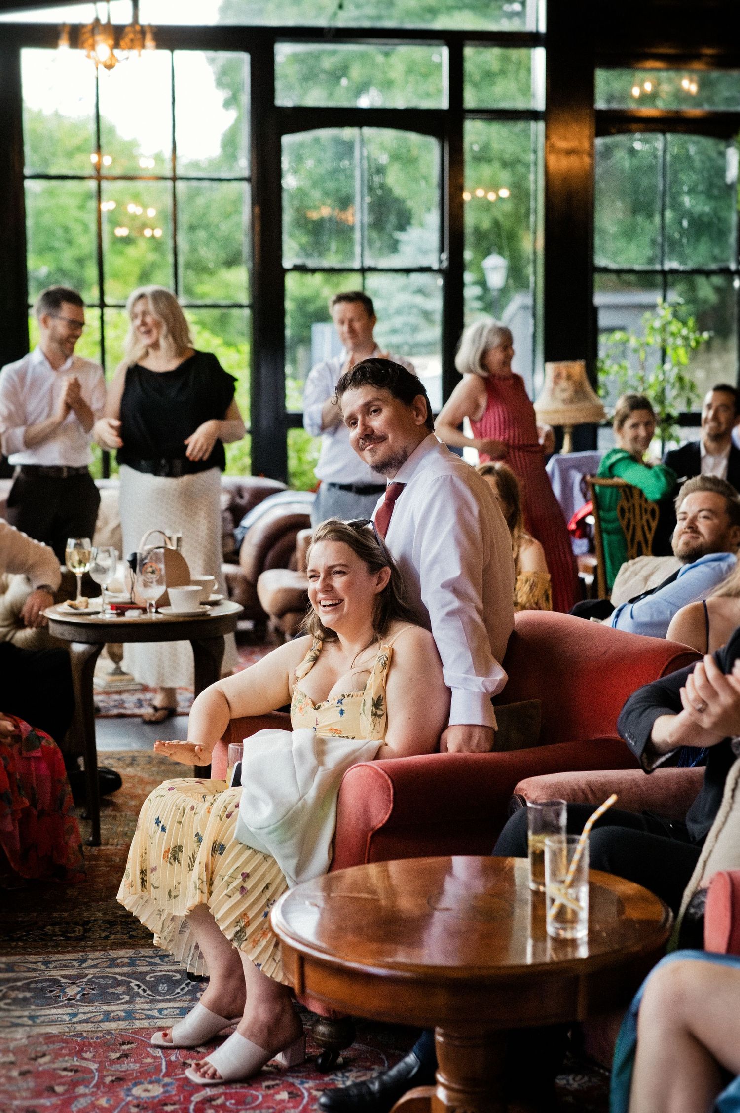 Bride and groom relax with guests in an elegant vintage lounge at wedding reception.