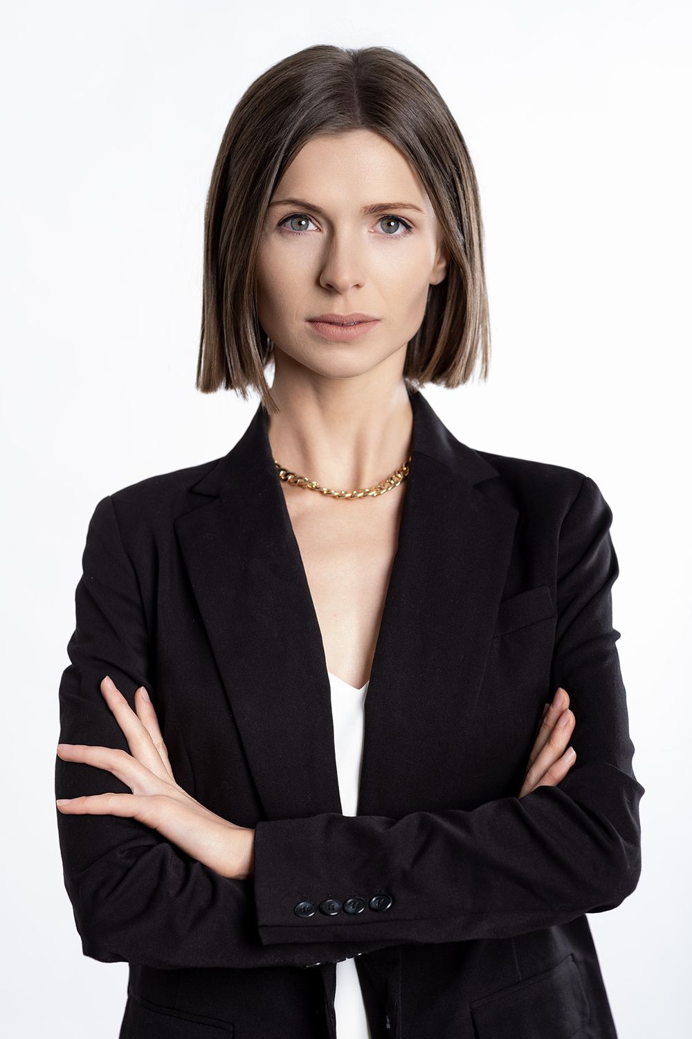 Professional business headshot of a confident woman wearing a blazer against a white studio background by Minneapolis portrait photographer.