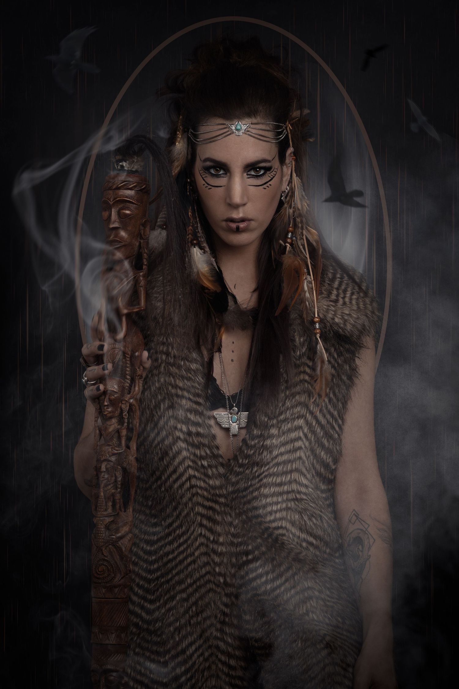 Mystical shaman woman in tribal attire holds a carved staff, adorned with feathers and face paint, surrounded by smoke.