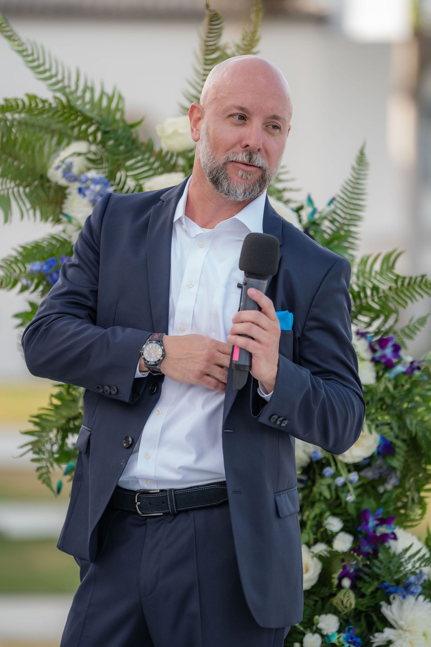 Groom speaking beside the floral arch during a South Terrace ceremony at the Mansion at Tuckahoe