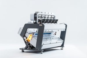 Industrial color sorter machine with multiple chutes and ejectors on a white background.