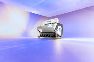 Industrial grain color sorter machine displayed against a vibrant purple and blue gradient studio background.