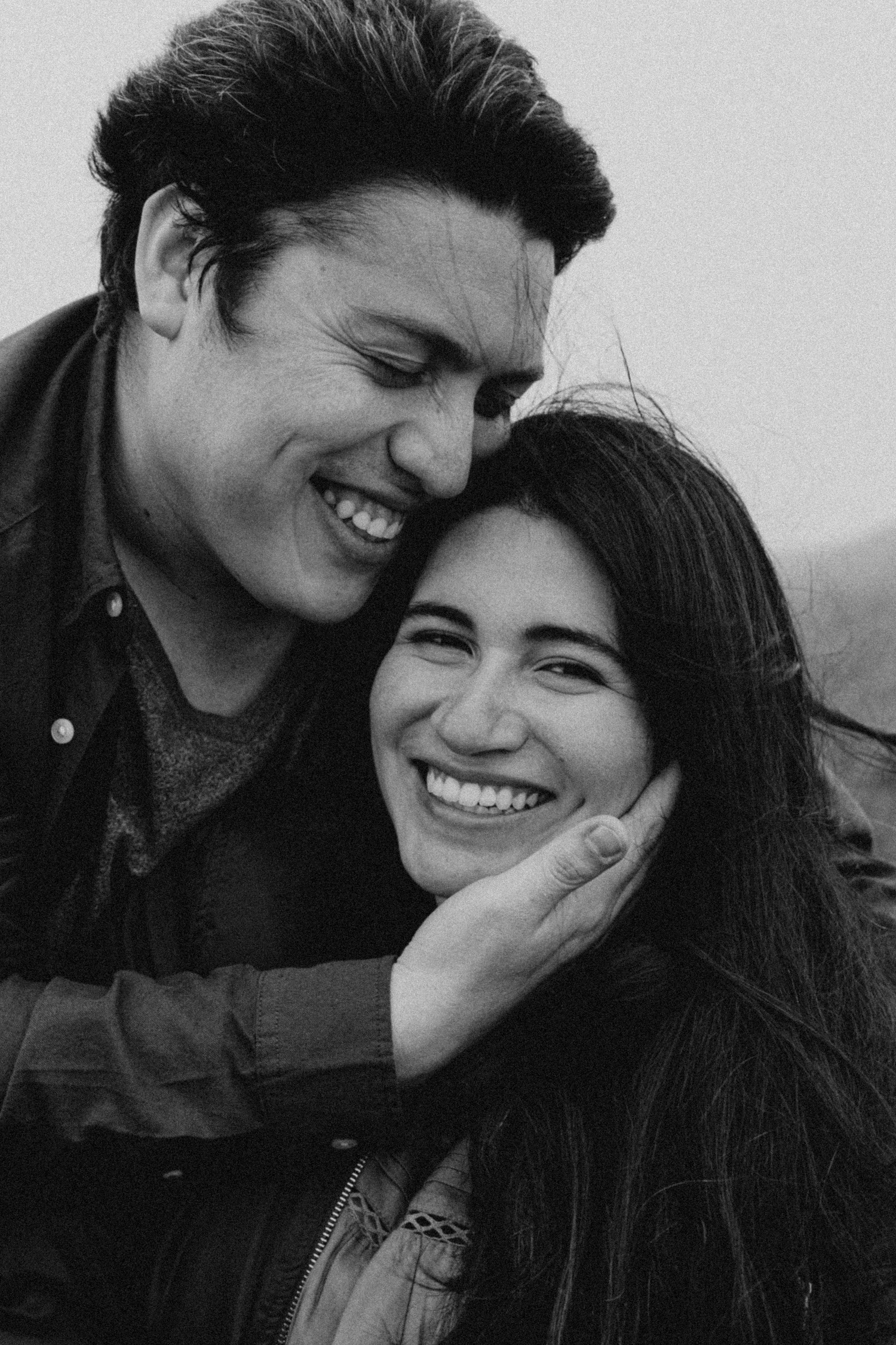 Black and white candid portrait of happy couple sharing tender moment together.