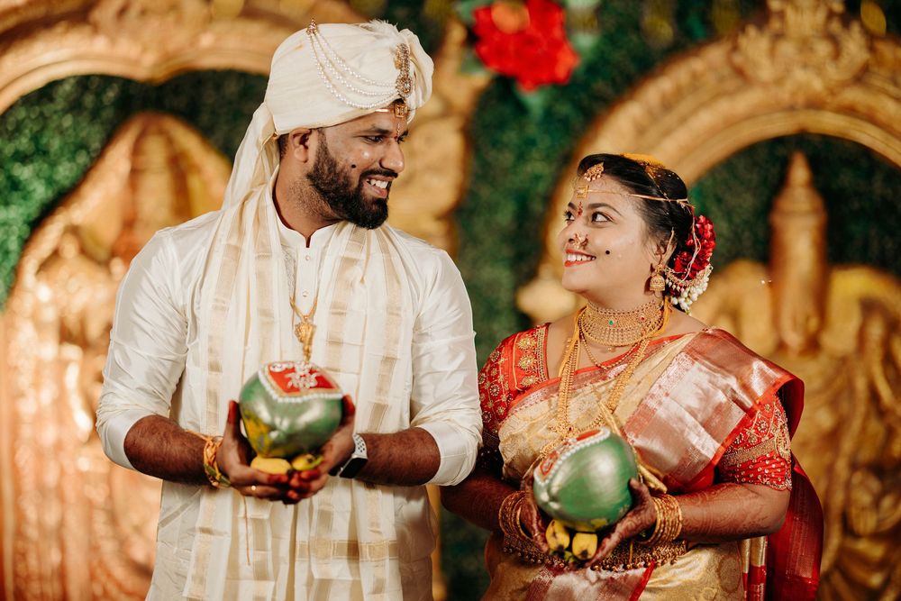 South Indian bride and groom holding coconut lamps during traditional Hindu wedding ritual ceremony.