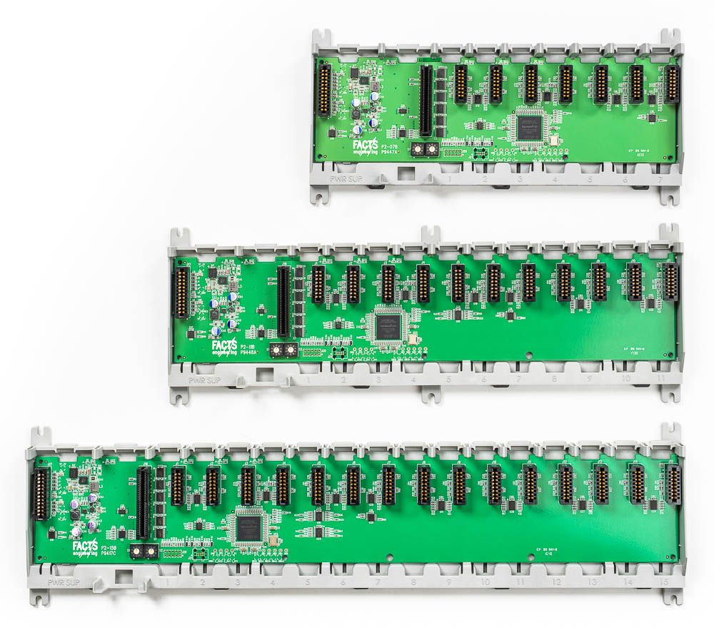 Machinery controllers | Three green PCB circuit boards of varying sizes mounted on DIN rails with electronic components.