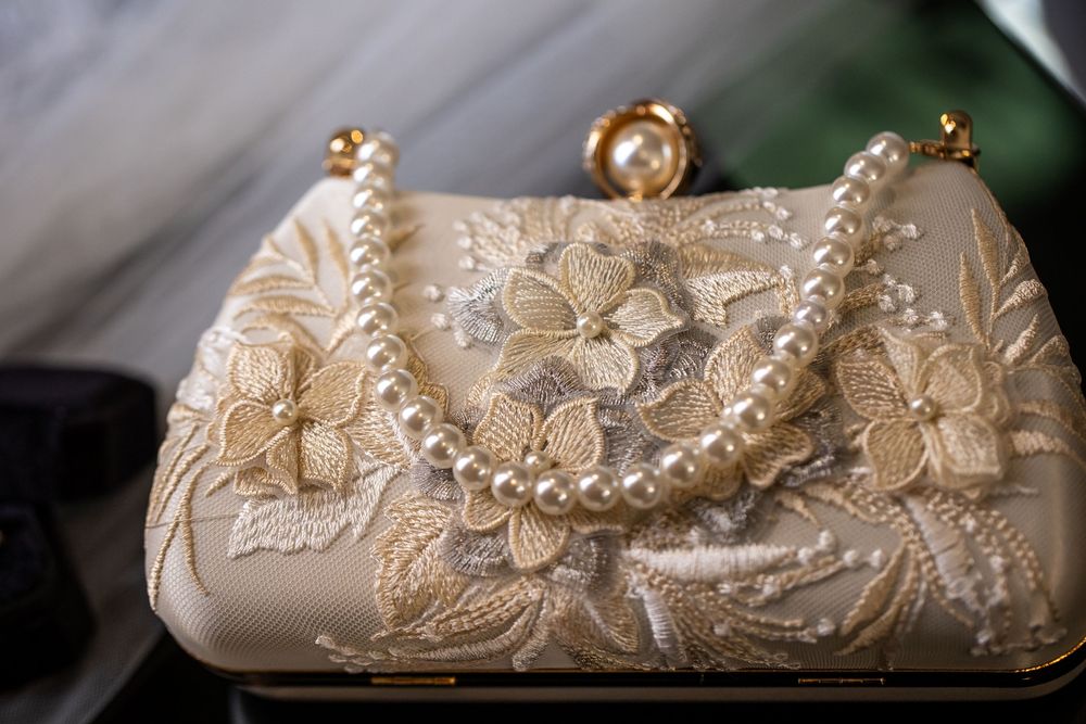 Ivory floral lace evening clutch with pearl bead strap and pearl clasp, ideal for weddings and formal occasions.