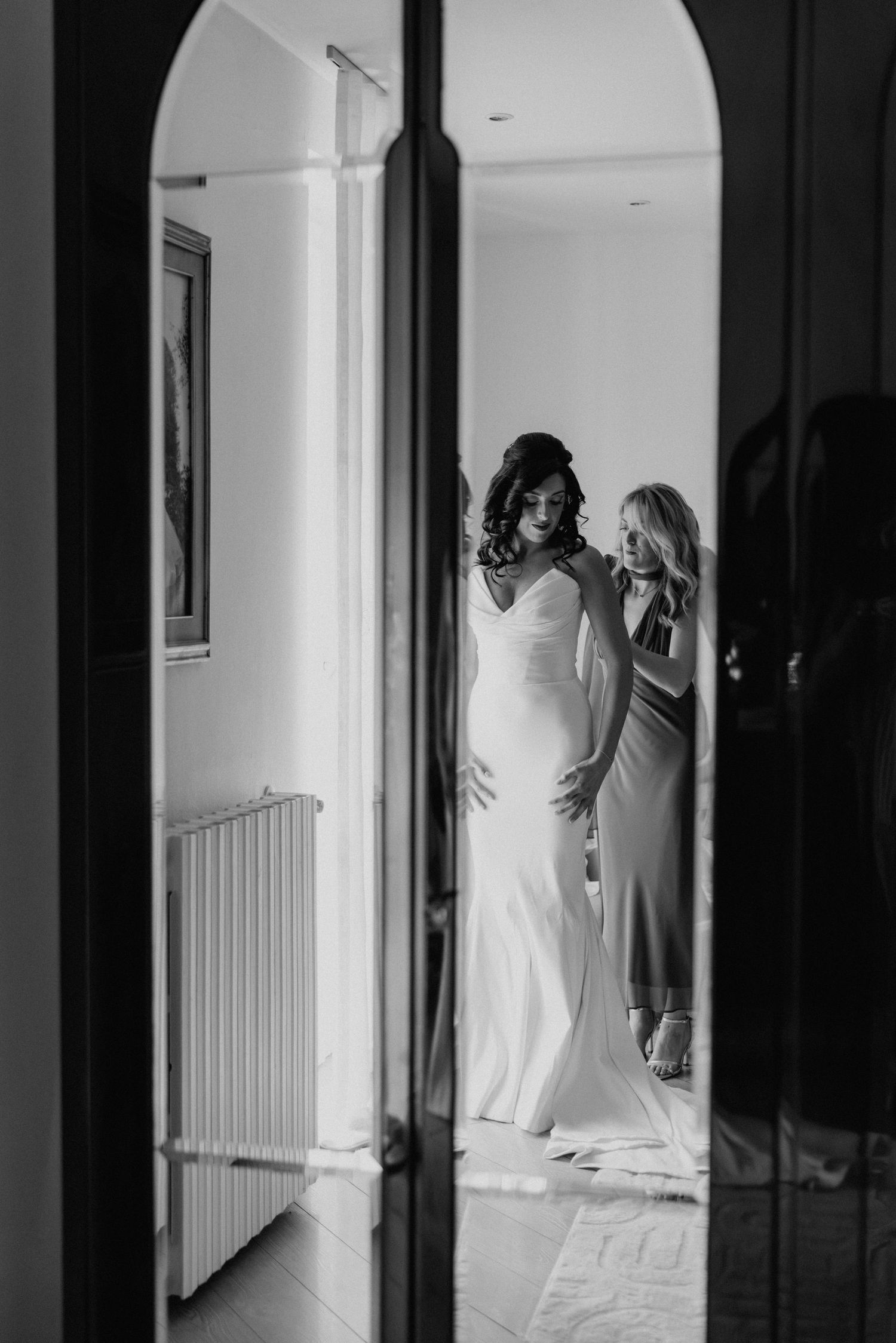 Elena in abito da sposa riflessa nello specchio, in bianco e nero.