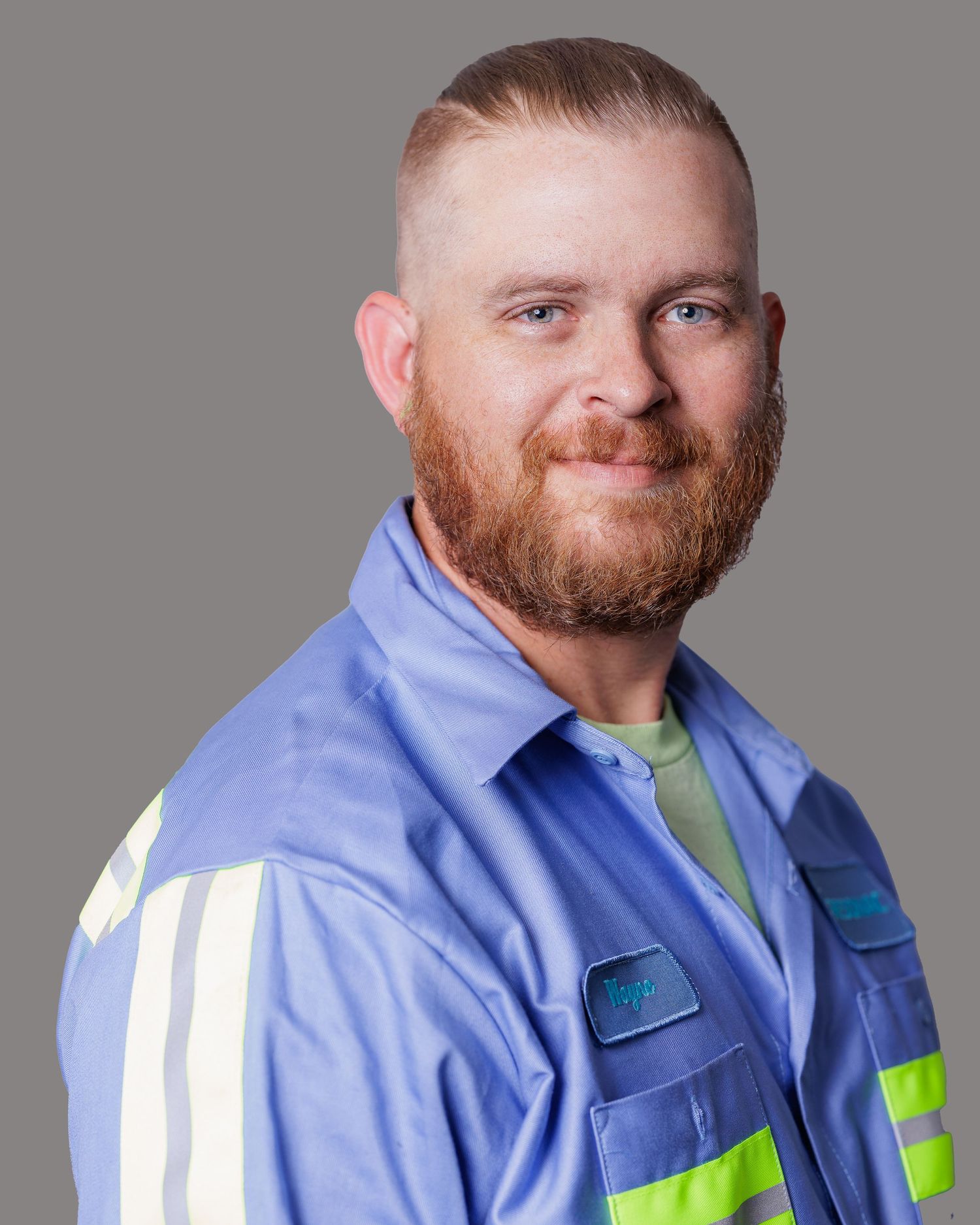 Portrait series of a person wearing a blue high-visibility work uniform against a gray backdrop.