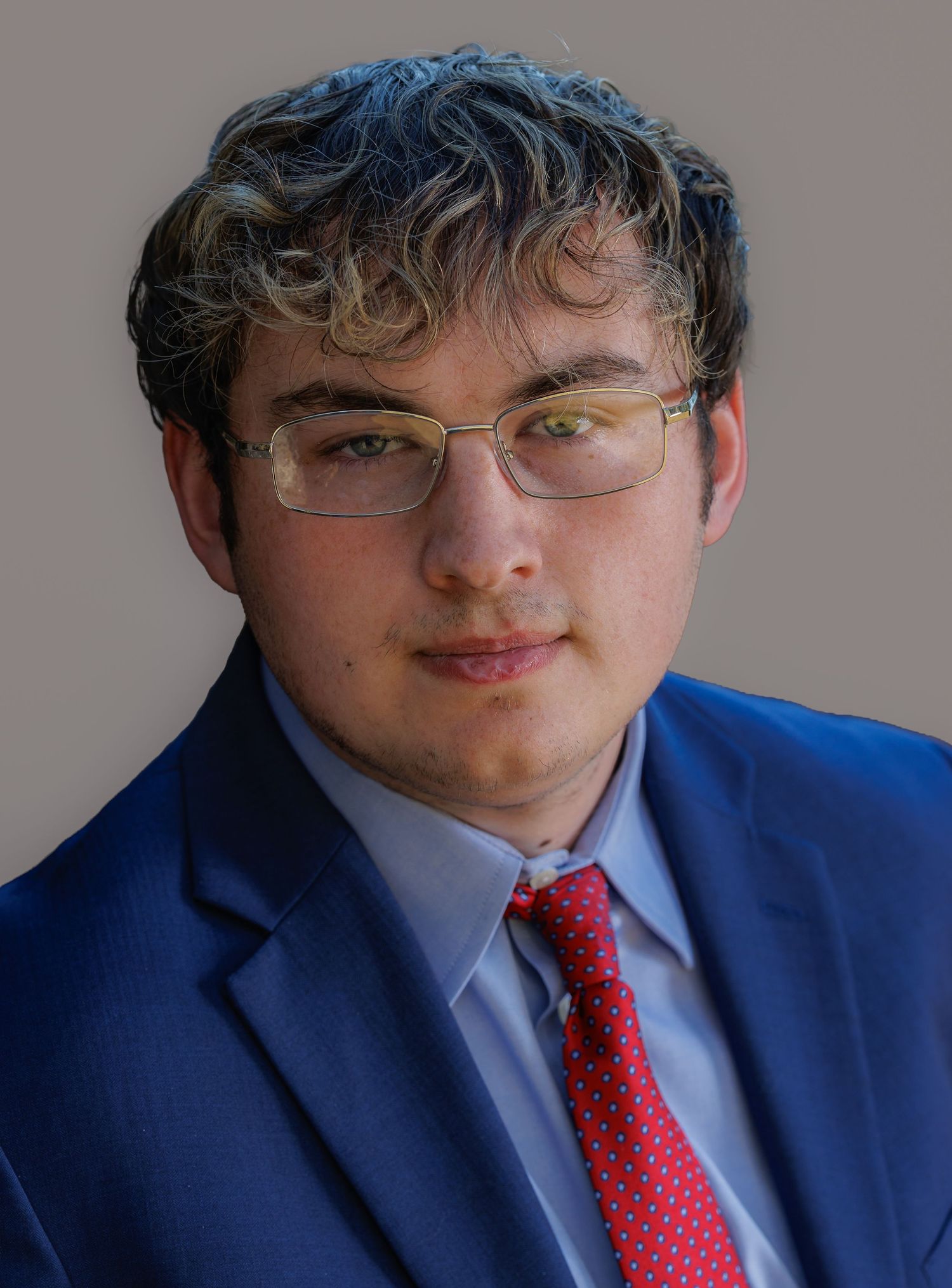 Close-up portrait series showing details of a blue suit, red tie, and glasses combination.