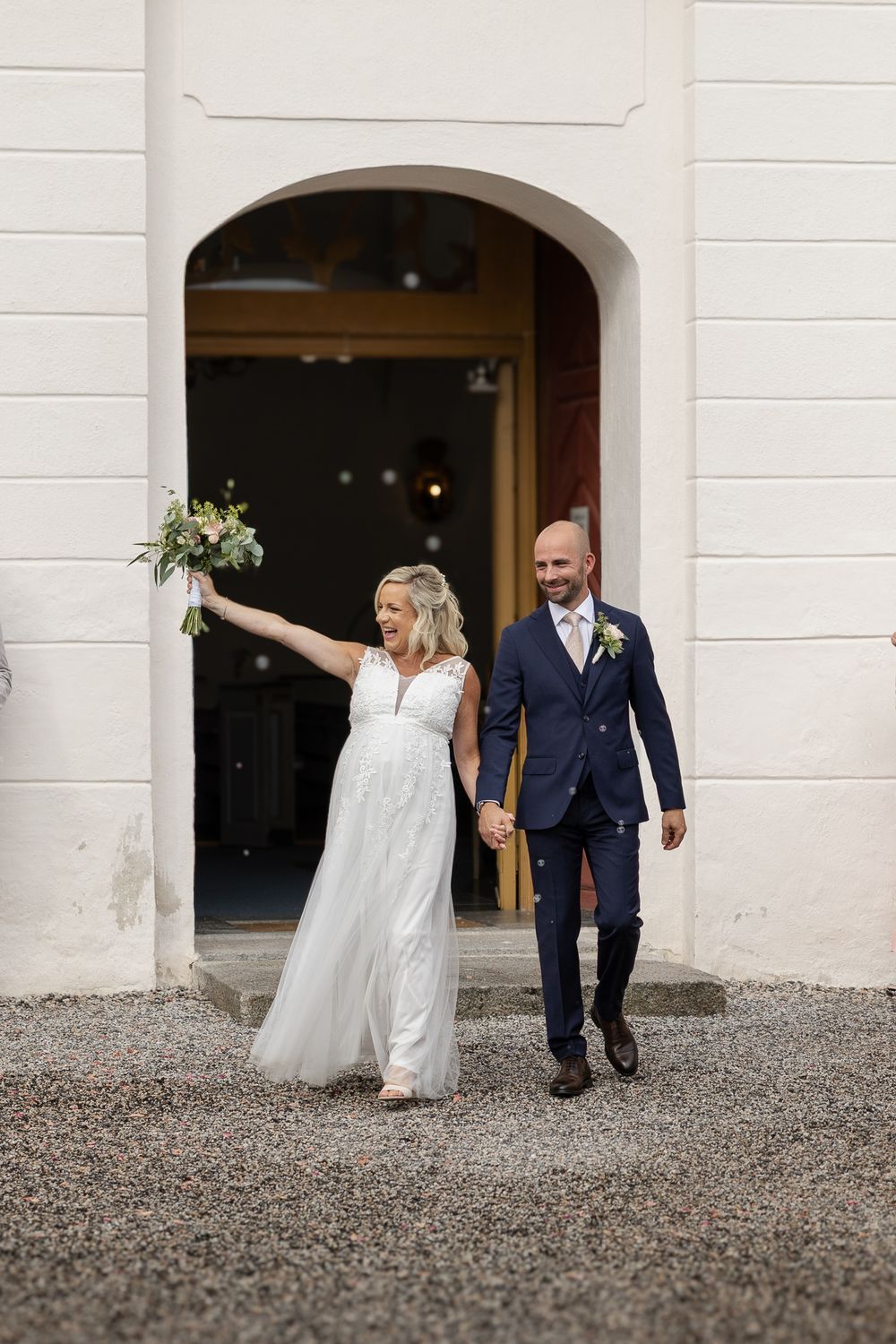 Brudpar påväg ut från kyrkan efter vigsel