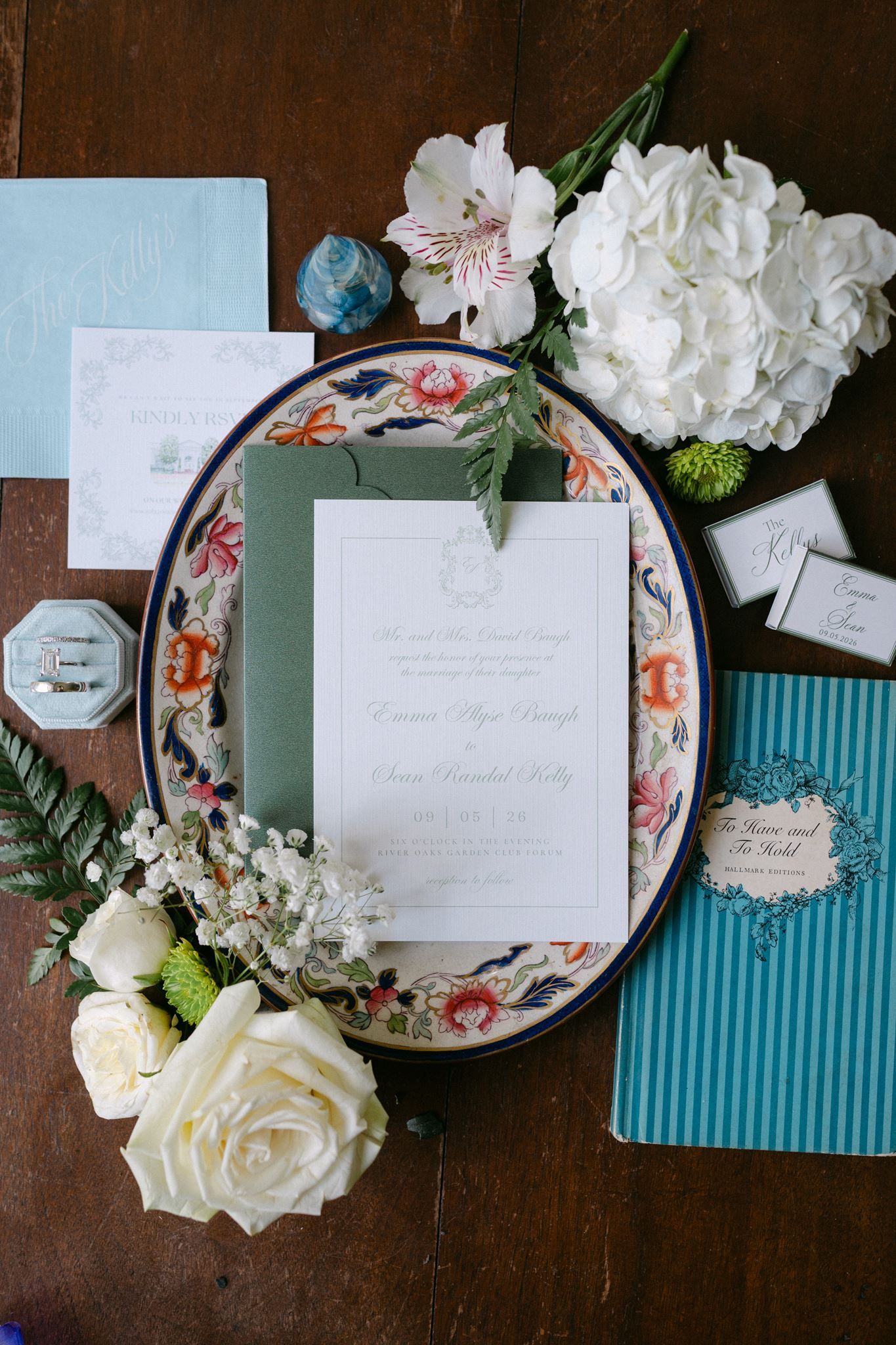 Flatlay of wedding day details, including wedding rings and invitation.