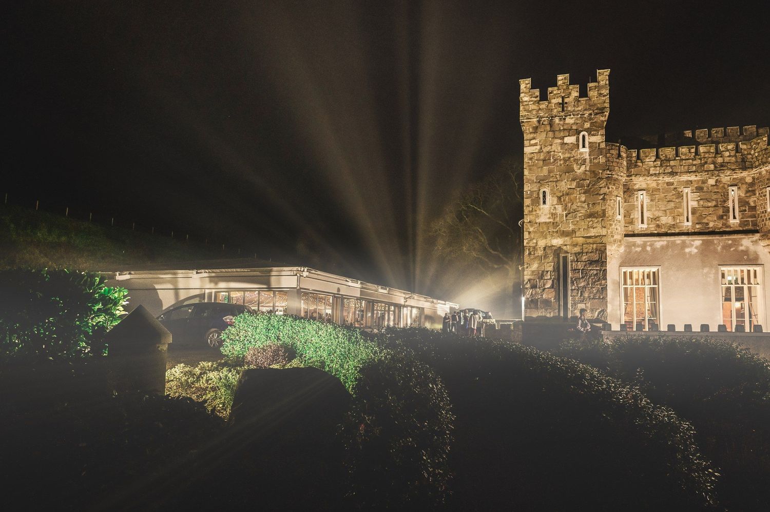 Killeavy Castle illuminated at night beside the garden bridge.