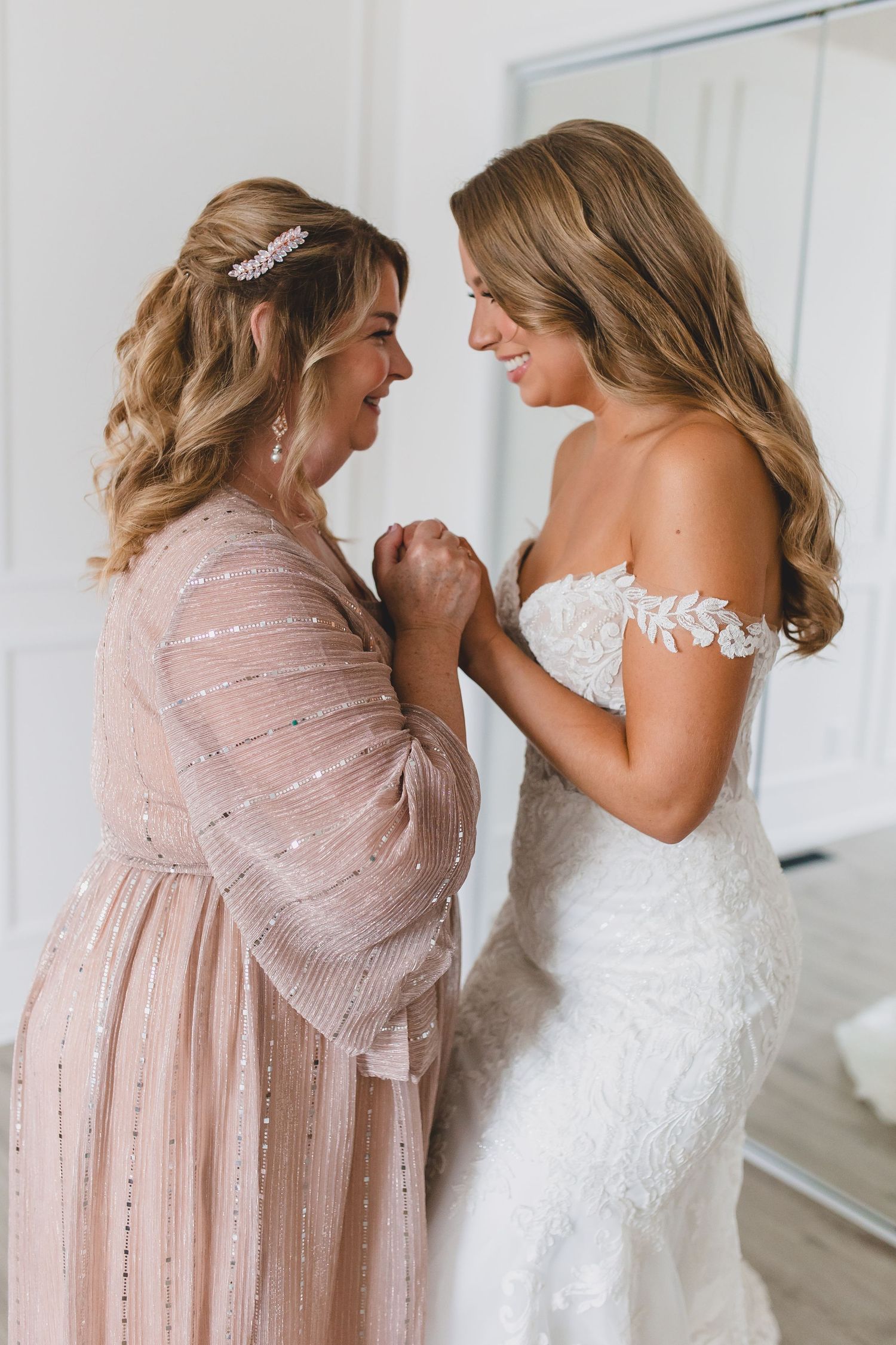 An emotional moment captured as two women share a tender moment in formal dresses, one in pink and one in white lace.  Starlit Point